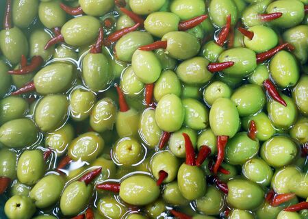 olives with hot red paper, chilli, picking from plants during harvesting, greenの写真素材