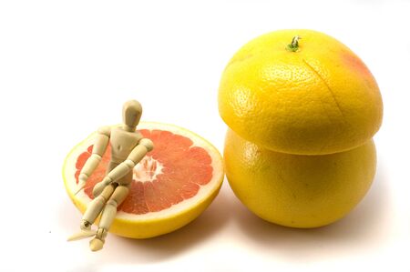 Composition with wooden man ang grapefruits on the white backgroundの写真素材