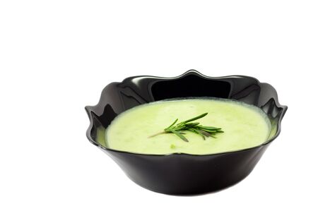 Green soup on the black plate on whote backgroundの写真素材
