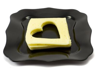 Cuted hearts from cheese, isolated, black plateの写真素材