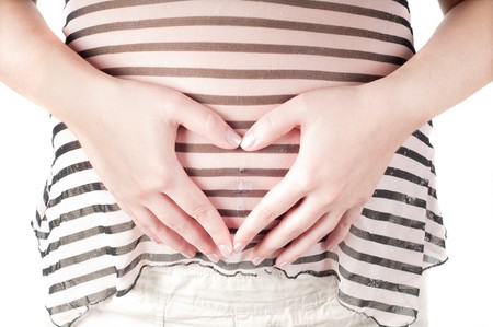 Pregnant woman hands in form of heart signの写真素材