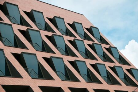 Pink modernd building with many black windows and blue skyのeditorial素材