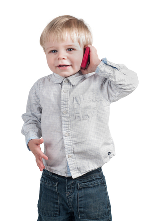 Little cute boy speaking on the pink phoneの写真素材