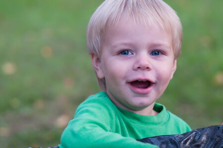 Happy smiling baby boy in green topの写真素材