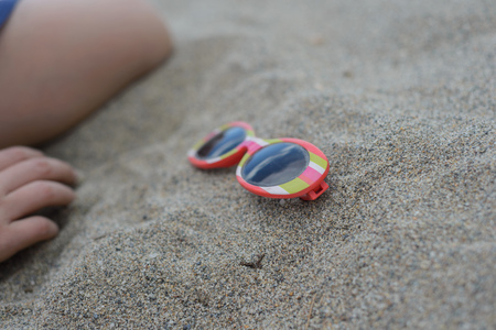 Striped sunglasses in the sandの写真素材