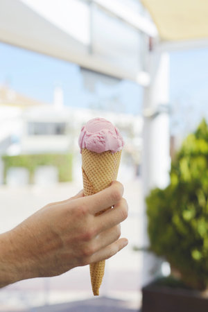 Hand holding pink ice-cream