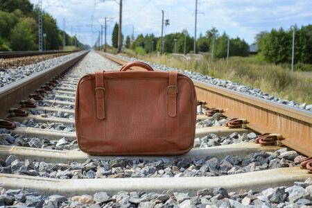 Vintage brown suitcase on the railwayの写真素材