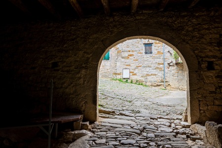 Dark passageway with arch to the light with old paving stoneの写真素材