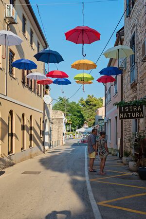 NOVIGRAD, CROATIA - AUGUST 8, 2016: street with multicolored umbrellasのeditorial素材