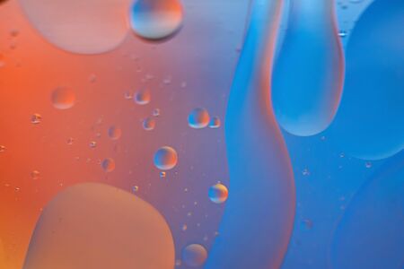 Oil drops in water. Defocused abstract psychedelic pattern image orange and blue colored. Abstract background with colorful gradient colors. DOF.の写真素材