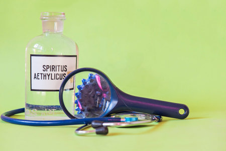 Ethanol in a bottle on the table with of microscope virus close up, stethoscope and loupe....