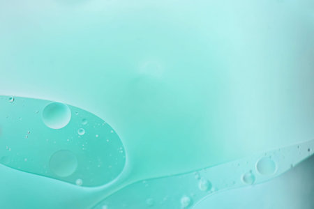 Oil drops in water. Defocused abstract psychedelic pattern image light blue colored. DOF.