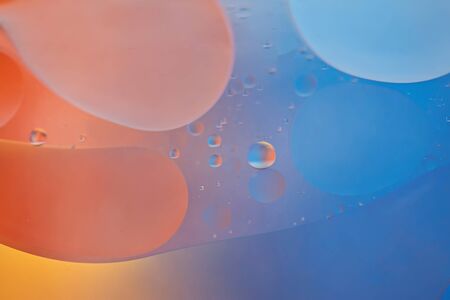 Oil drops in water. Defocused abstract psychedelic pattern image orange and blue colored. Abstract background with colorful gradient colors. DOF.の写真素材