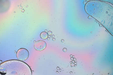 Holographic colorful abstract background with oil drops on waterの写真素材