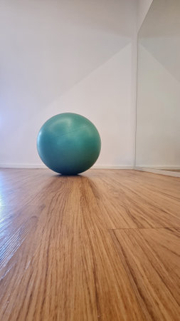 Green exercise ball on wooden floor in modern interiorの写真素材