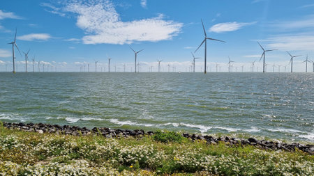 Windmills along a vast body of waterの写真素材