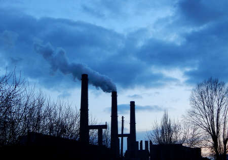 Smokestacks make pollutions into blue skyの写真素材
