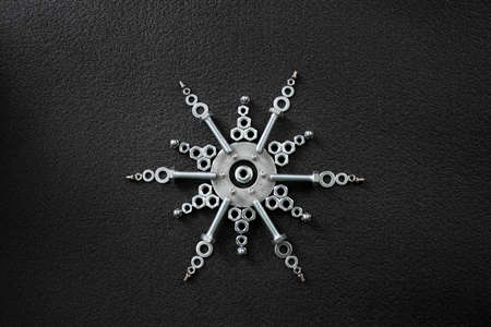 Metal art. Flower from bolts and washers on black backgroundの写真素材
