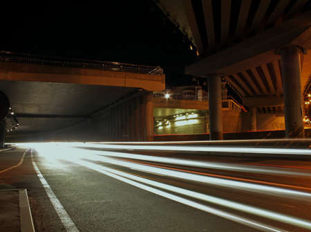 Night scene of city street with lighting on bridge and car lights tracesの写真素材