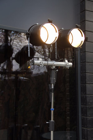 Spotlights on tripod over glass wall