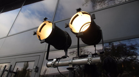 Spotlights on tripod over glass wall