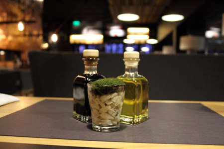 Olive oil, balsamic vinegar, garlic and herbs in table seasoning set at the restaurantの写真素材