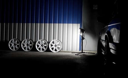 Set of dismantled white sport car wheels near car tyre service workshopの写真素材