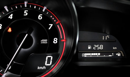 Close up glowing tachometer needle at zero engine speed on the car dashboard