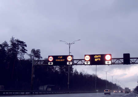 Vehicles driving under illuminated road sign at nightのeditorial素材
