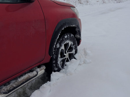 Cars wheel fell into the snow at winter off road travel