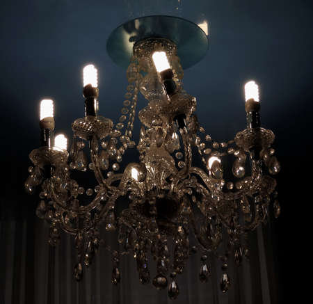 Modern electric bulbs shines in ceiling lustre in old classic styleの写真素材