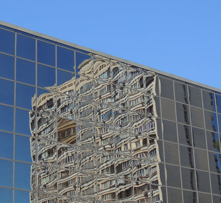 Reflection Of Multi Story House In Glass Facade Of Modern Buildingの写真素材