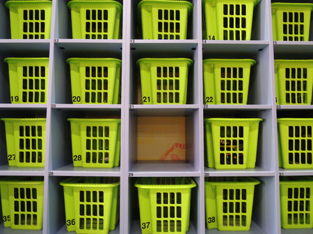 Empty cell among filled cells with plastic storage boxes at storage roomの写真素材