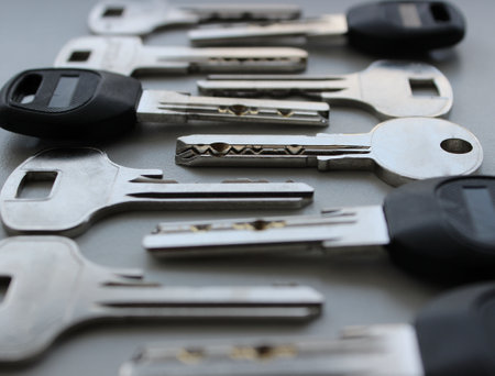 Laid out one by one modern lock keys angle view extreme closeup stock photoの写真素材
