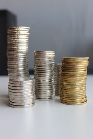 Money In Coins Are Stacked In Piles Of Different Heights