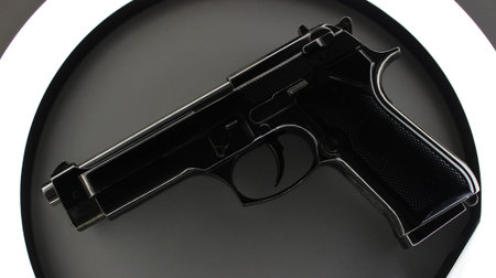 Automatic Handgun Inside Circle Of Light With Barrel Down