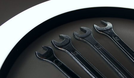 Variety Size Steel Wrenches Laid Out In Line Order Illuminated With Curved Lamp