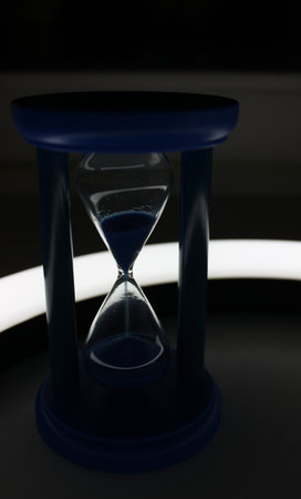 Sandglass with falling sand with soft backlight by curved lampの写真素材