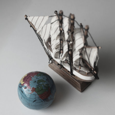 Miniature Globe Near Sailing Vessel Model On White Old Film Style Stock Photoの写真素材