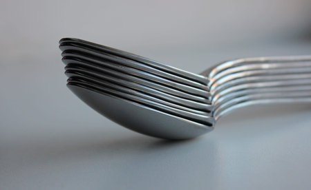 Stuck Of Same Size Silvery Spoons On Clean White Surface. Concept Photo For Table Setting...