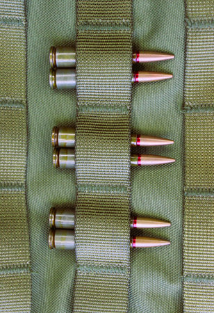 Combat cartridges are attached to tactical belts vertical stock photo for military backgrounds