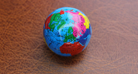 Miniature globe on a leather surface with conventionally drawn continents and trading routesの写真素材