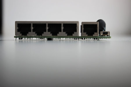 Electronic board with integrated slots for network connection and pins for soldering closeup side...