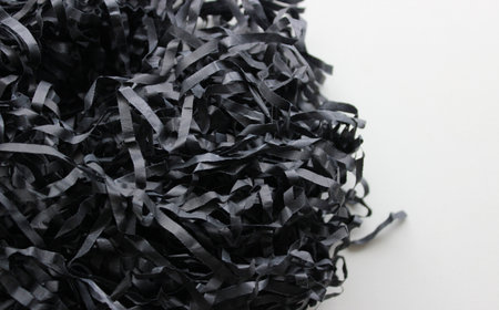 Bunch Of Black Shredded Paper On Clean White Surface. Texture Of Paper Shavings Detailed Stock Photoの写真素材