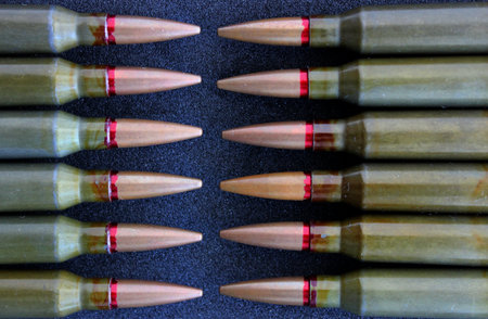 Pattern of live ammunition laid out bullet to bullet on a black background detailed stock photoの写真素材
