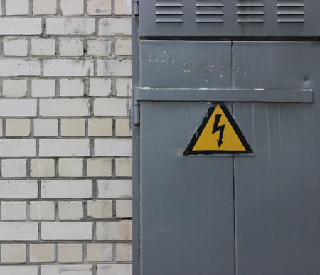 High Voltage Sign On A Steel Door On A White Brick Wall Texture Backgroundの写真素材
