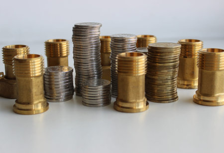 Columns of coins and water high pressure fittings as an illustration