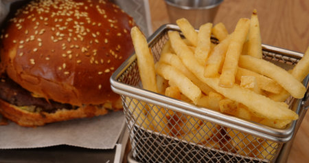 Serving a fast menu of beef burger and french fries in a special basketの写真素材