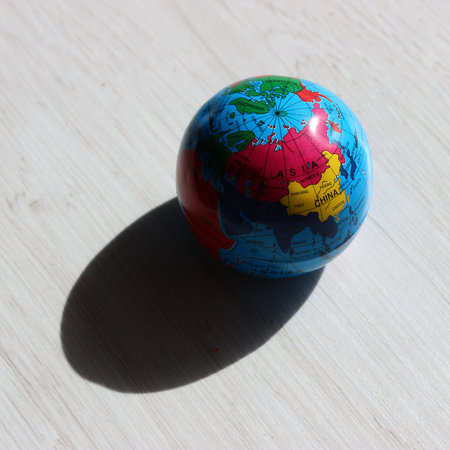 A deep shadow cast by a globe on the illuminated side, showing the countries of the Asian continent....