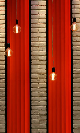Fabric textured panels on a brick wall illuminated by hanging lamps stock image for vertical storyの写真素材